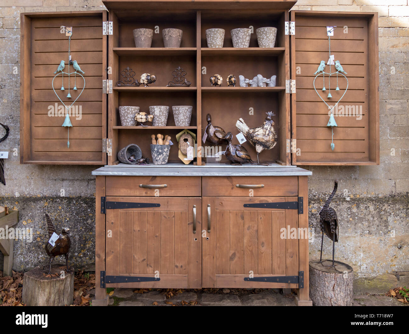 Rustic wooden dresser used as outdoor shop display cabinet with shelves, doors and drawers, UK Stock Photo