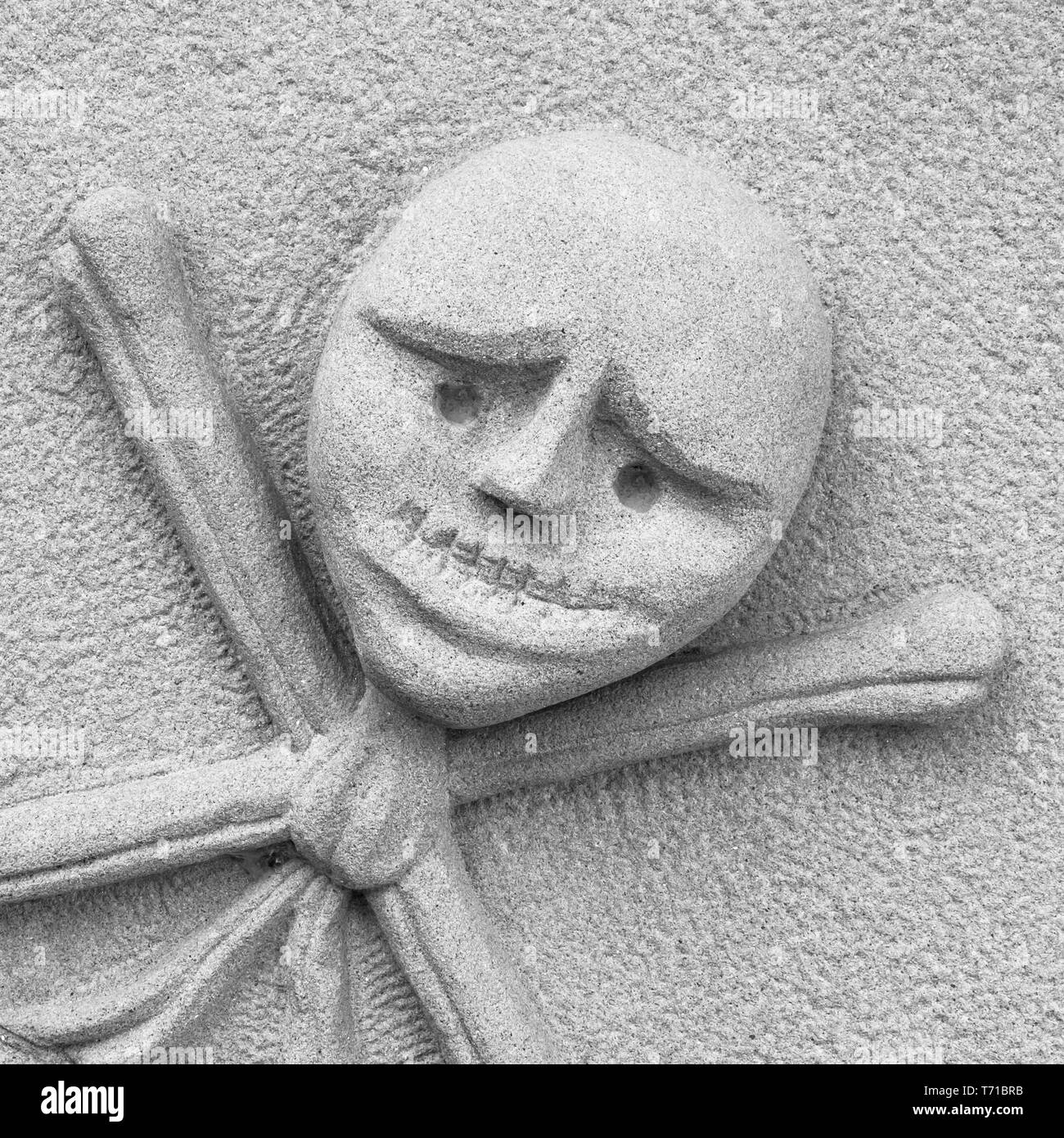 Stone sculpture of the skull with crossbones Stock Photo