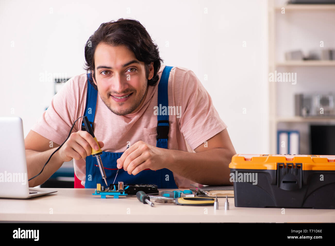 Young male contractor repairing computer Stock Photo