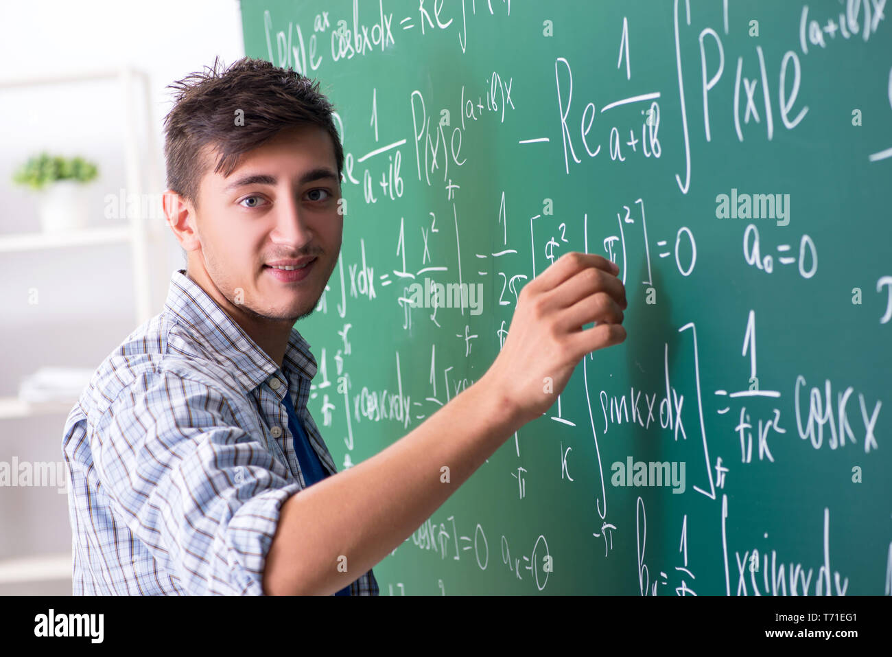 Young male student studying math at school Stock Photo - Alamy