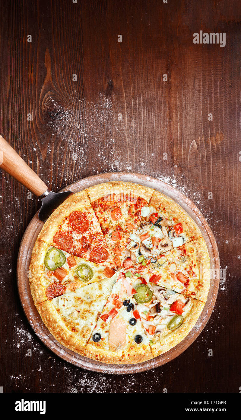 mix of eight different pizzas on a wooden background. menu concept of choice and diversity Stock Photo