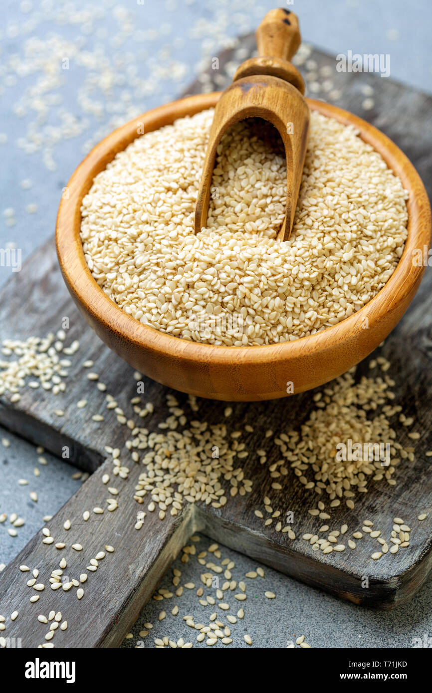 Bowl with sesame seeds and wooden scoop. Stock Photo