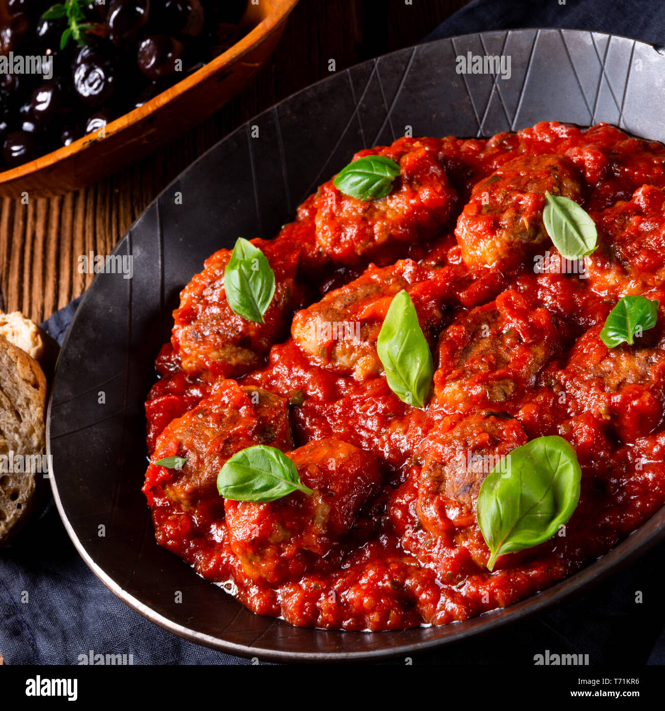 Baked mini meatballs in tomato sauce with basil Stock Photo Alamy