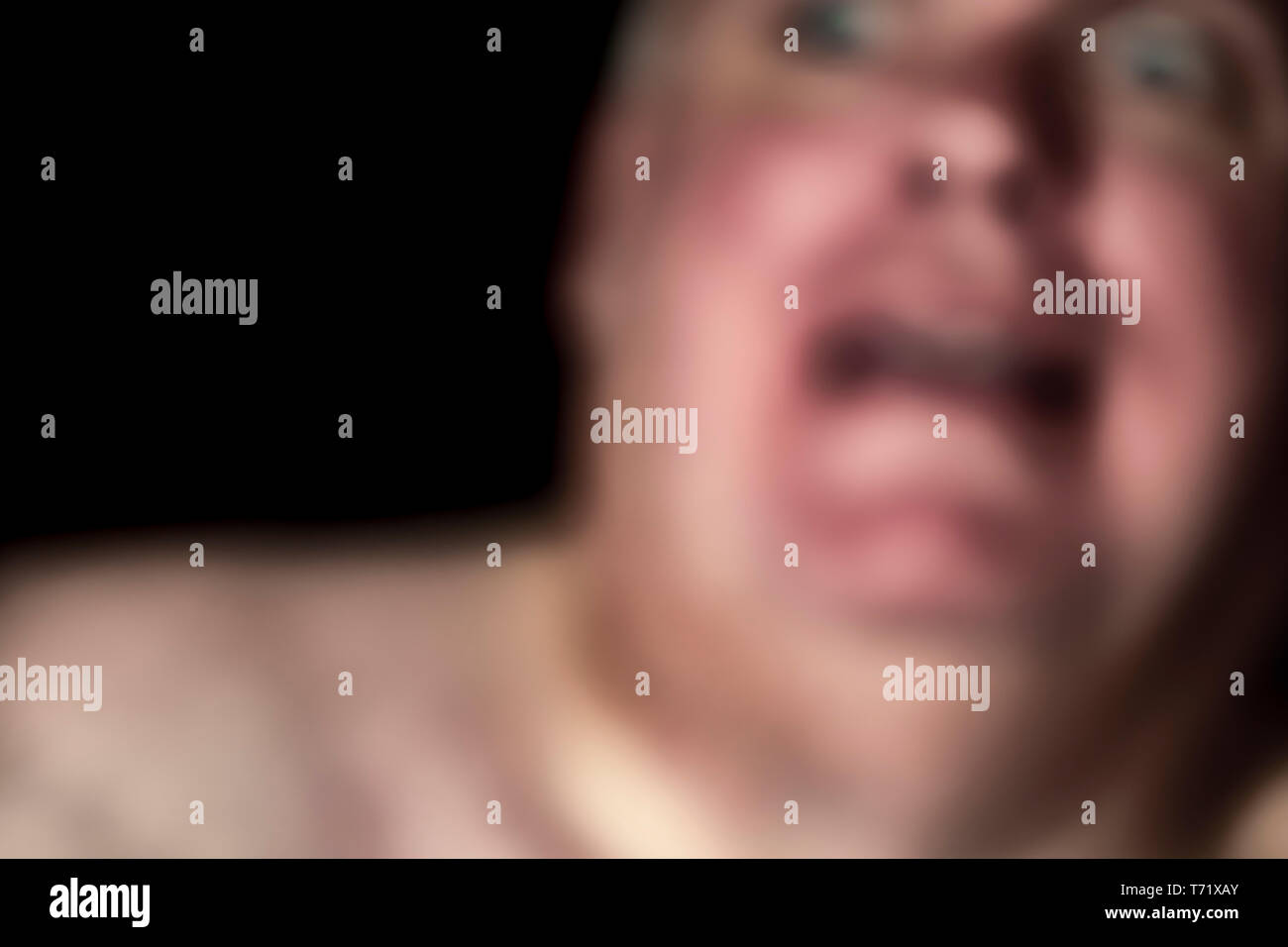 Abstract blurred image on a man with a petrified, frightened, scared stiff, shocked, terrified or surprised look on his face. Needing help. Copy space. Stock Photo
