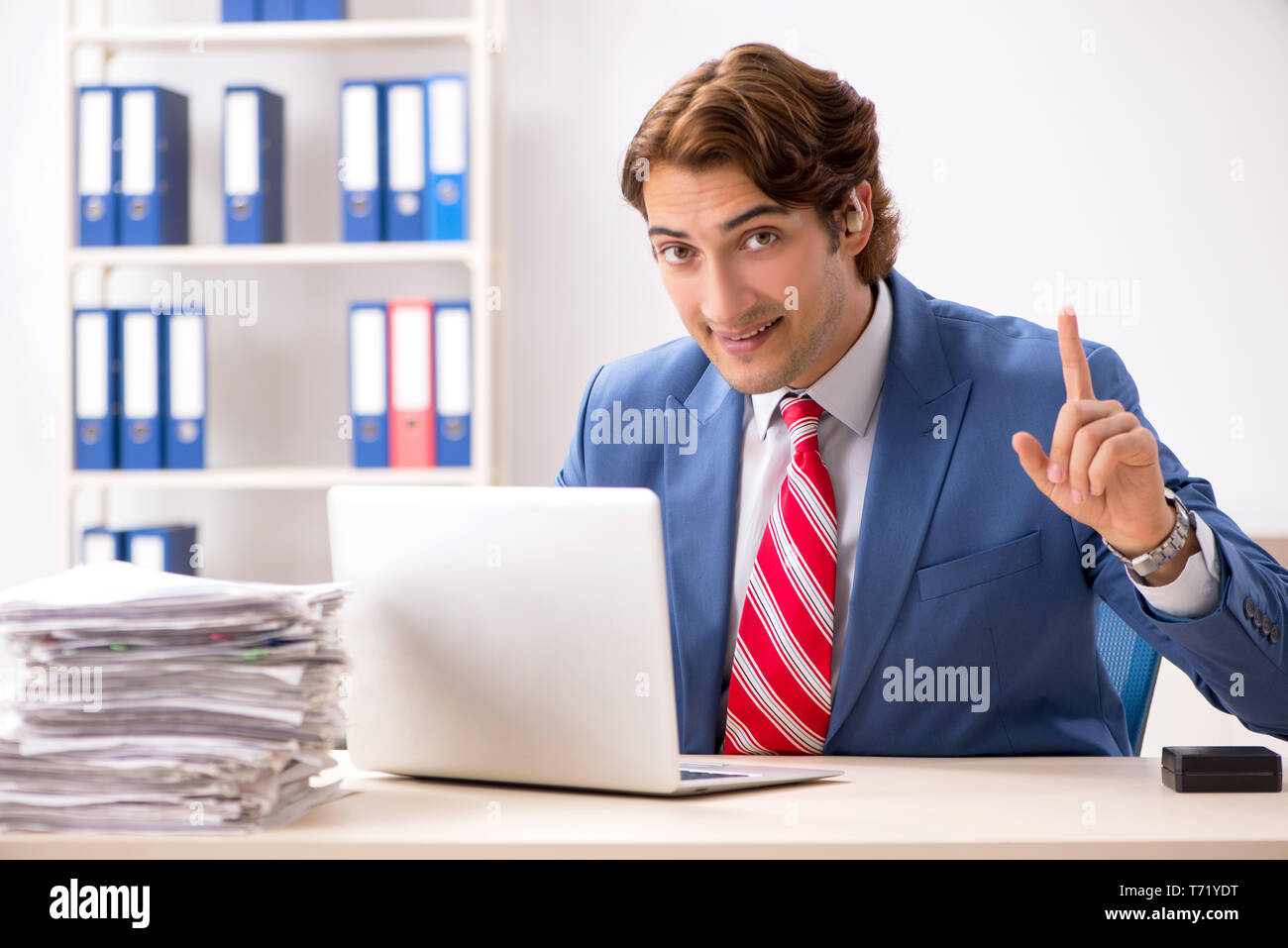 Deaf employee using hearing aid in office Stock Photo