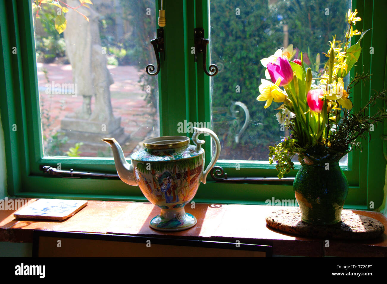 Green window with decorated window sill. Antique English style. Flowers ...