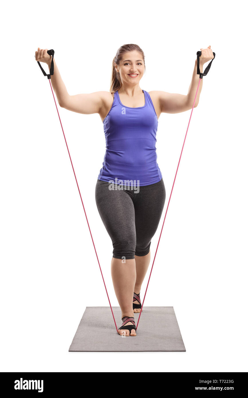 Full length portrait of a young woman exercising with a stretching band isolated on white background Stock Photo