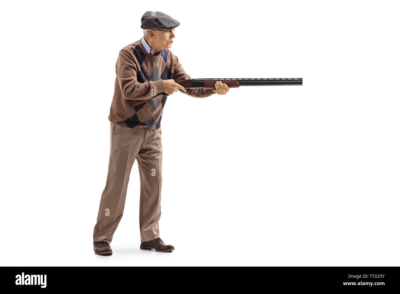 Full length profile shot of an elderly man aiming with a shotgun isolated on white background Stock Photo