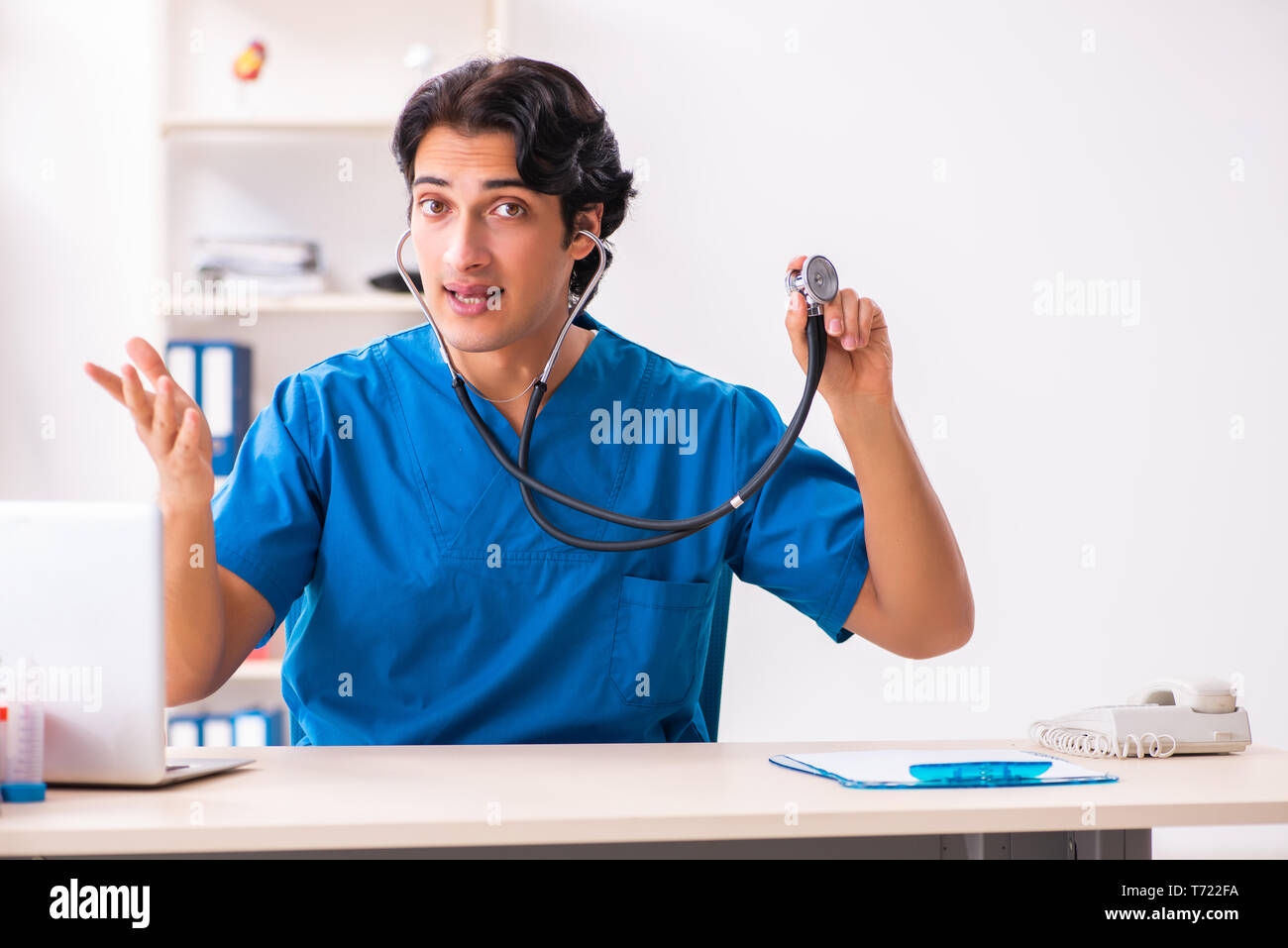 Handsome doctor listening young hi-res stock photography and images - Alamy