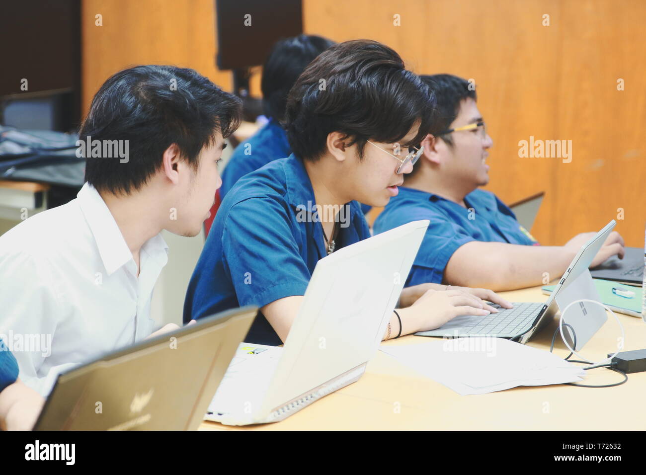 Groups of Thai Computer Engineering students at Assumption University (ABAC) Working on their coding project in a classroom Stock Photo