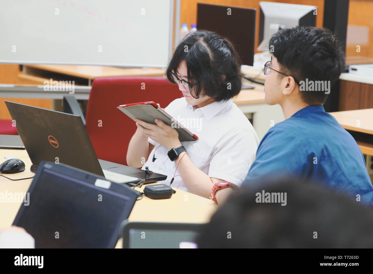 Chinese Computer Engineering Student taking lecture note on his iPad using Apple Pencil during a computer programming class Stock Photo