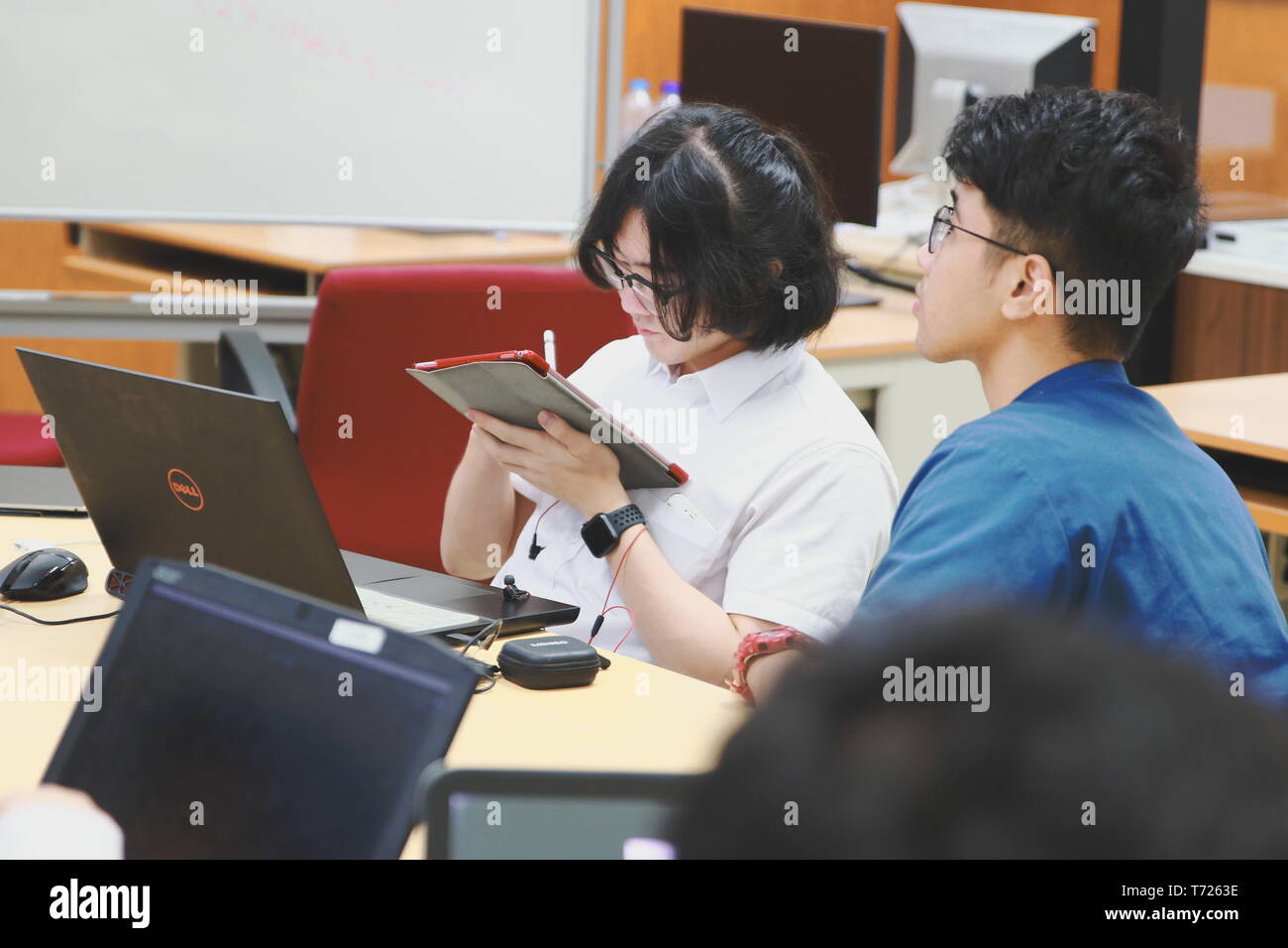 Chinese Computer Engineering Student taking lecture note on his iPad using Apple Pencil during a computer programming class Stock Photo