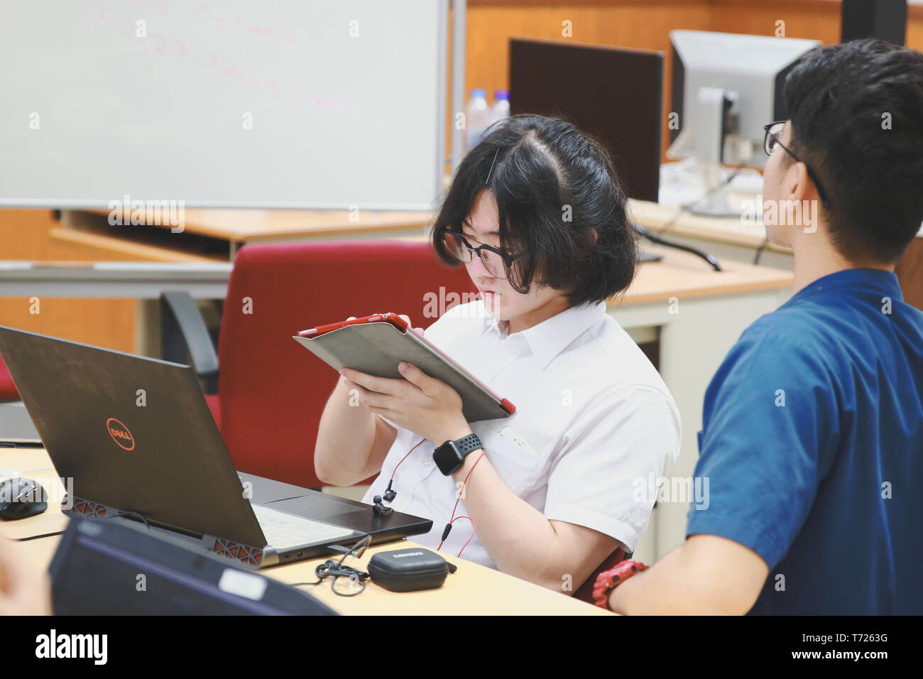 Chinese Computer Engineering Student taking lecture note on his iPad using Apple Pencil during a computer programming class Stock Photo