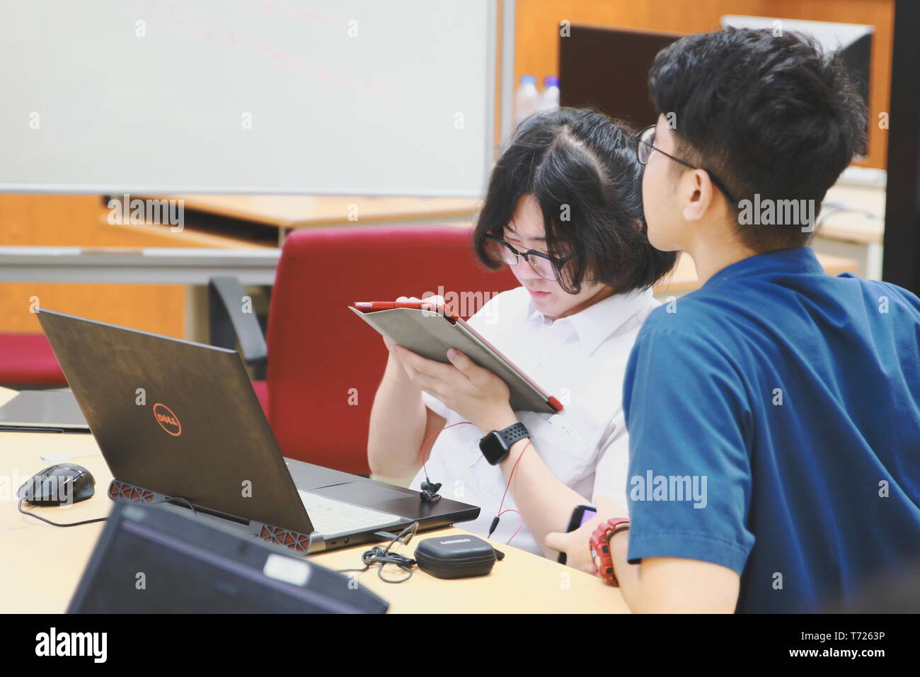Chinese Computer Engineering Student taking lecture note on his iPad using Apple Pencil during a computer programming class Stock Photo