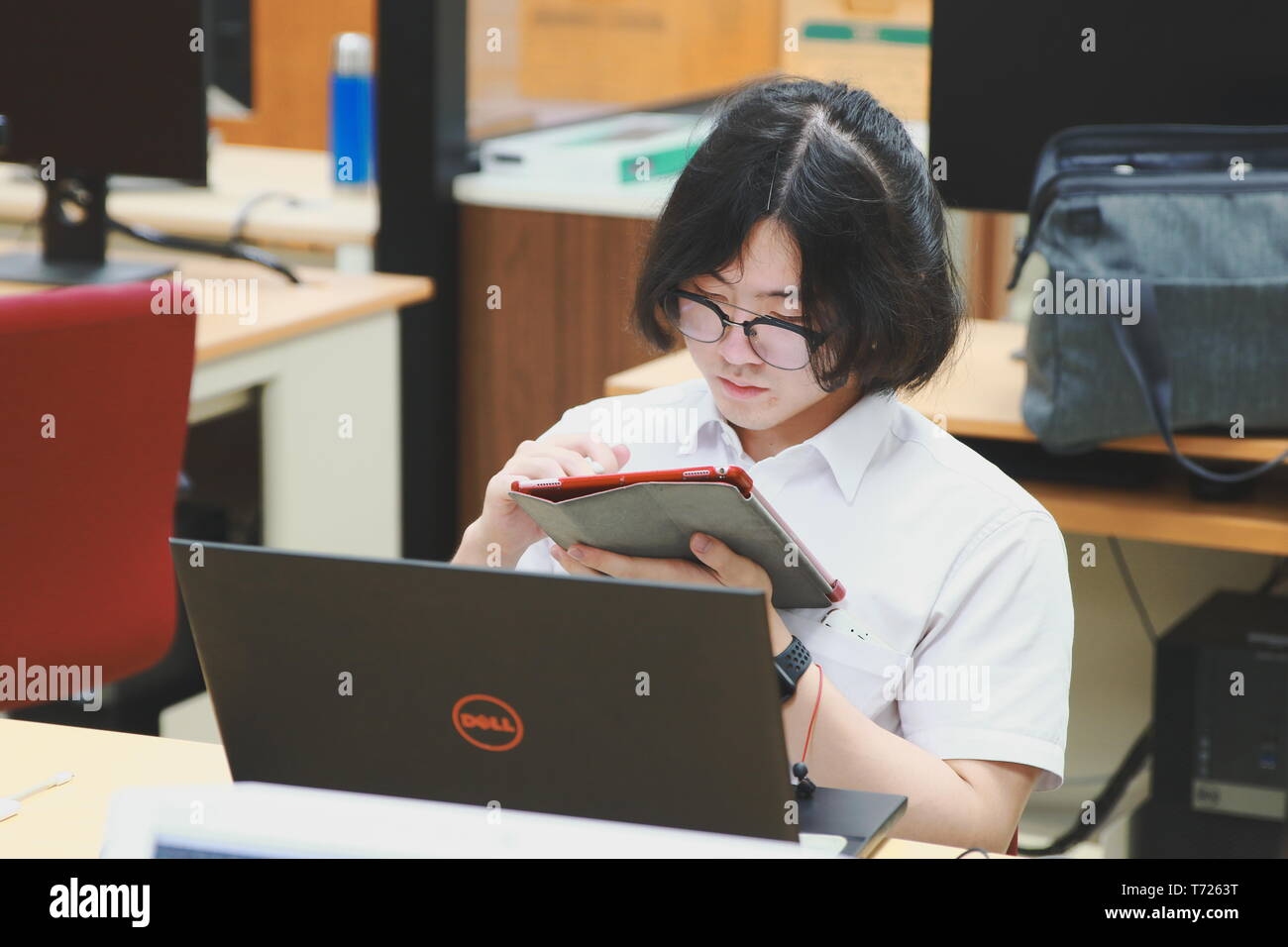 Chinese Computer Engineering Student taking lecture note on his iPad using Apple Pencil during a computer programming class Stock Photo