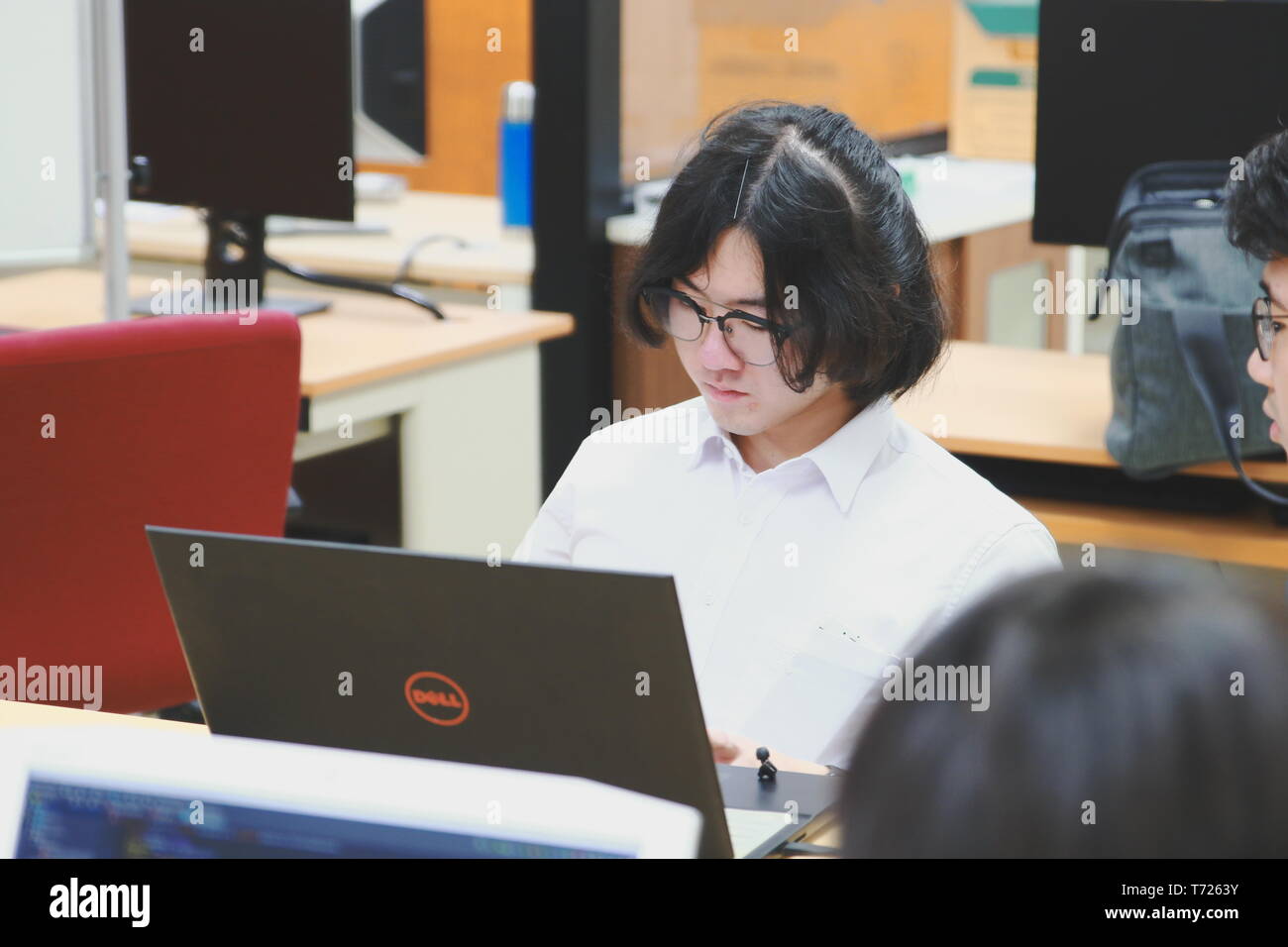 Chinese Computer Engineering Student taking lecture note on his iPad using Apple Pencil during a computer programming class Stock Photo