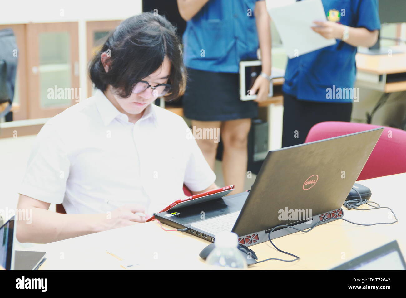 Chinese Computer Engineering Student taking lecture note on his iPad using Apple Pencil during a computer programming class Stock Photo