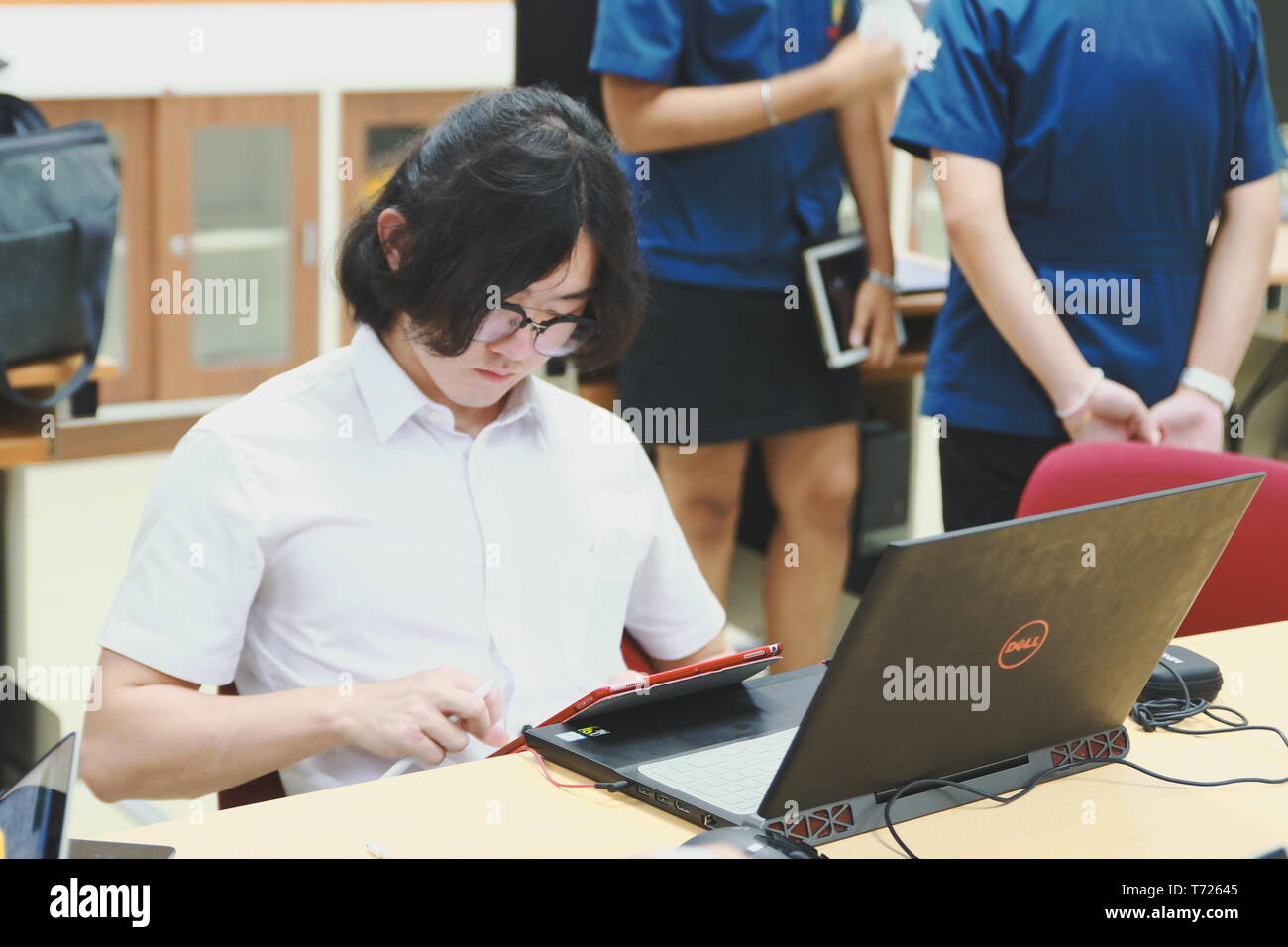 Chinese Computer Engineering Student taking lecture note on his iPad using Apple Pencil during a computer programming class Stock Photo