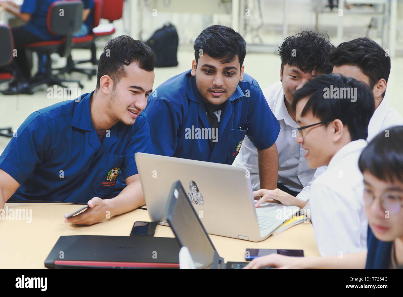 Group of Asian computer engineering students working together to ...