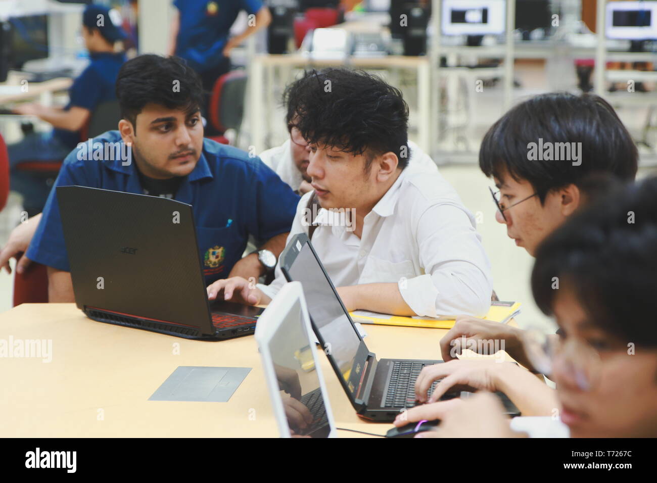 Group of Asian computer engineering students working together to complete a computer programming project at an University Stock Photo