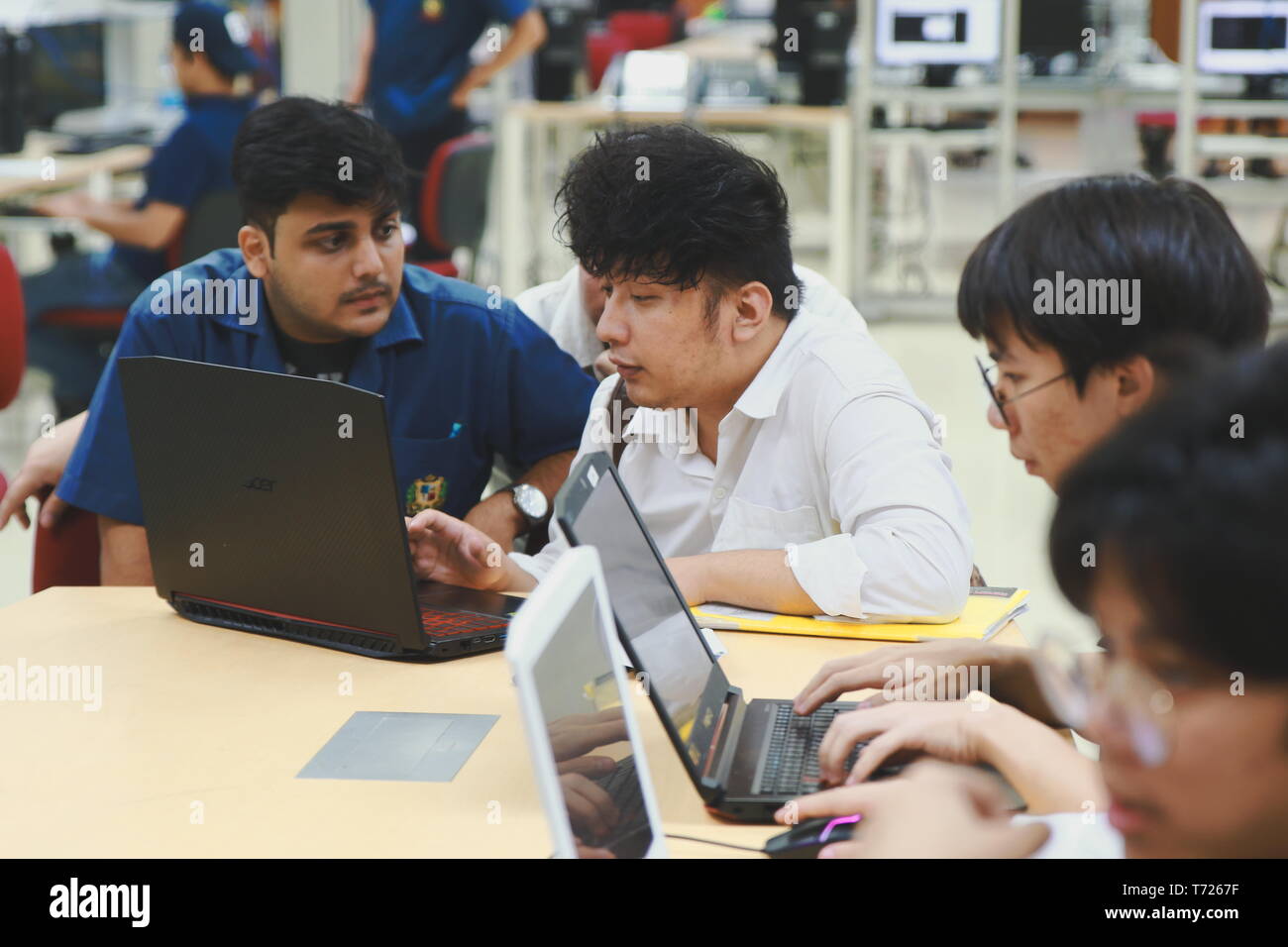 Group of Asian computer engineering students working together to complete a computer programming project at an University Stock Photo
