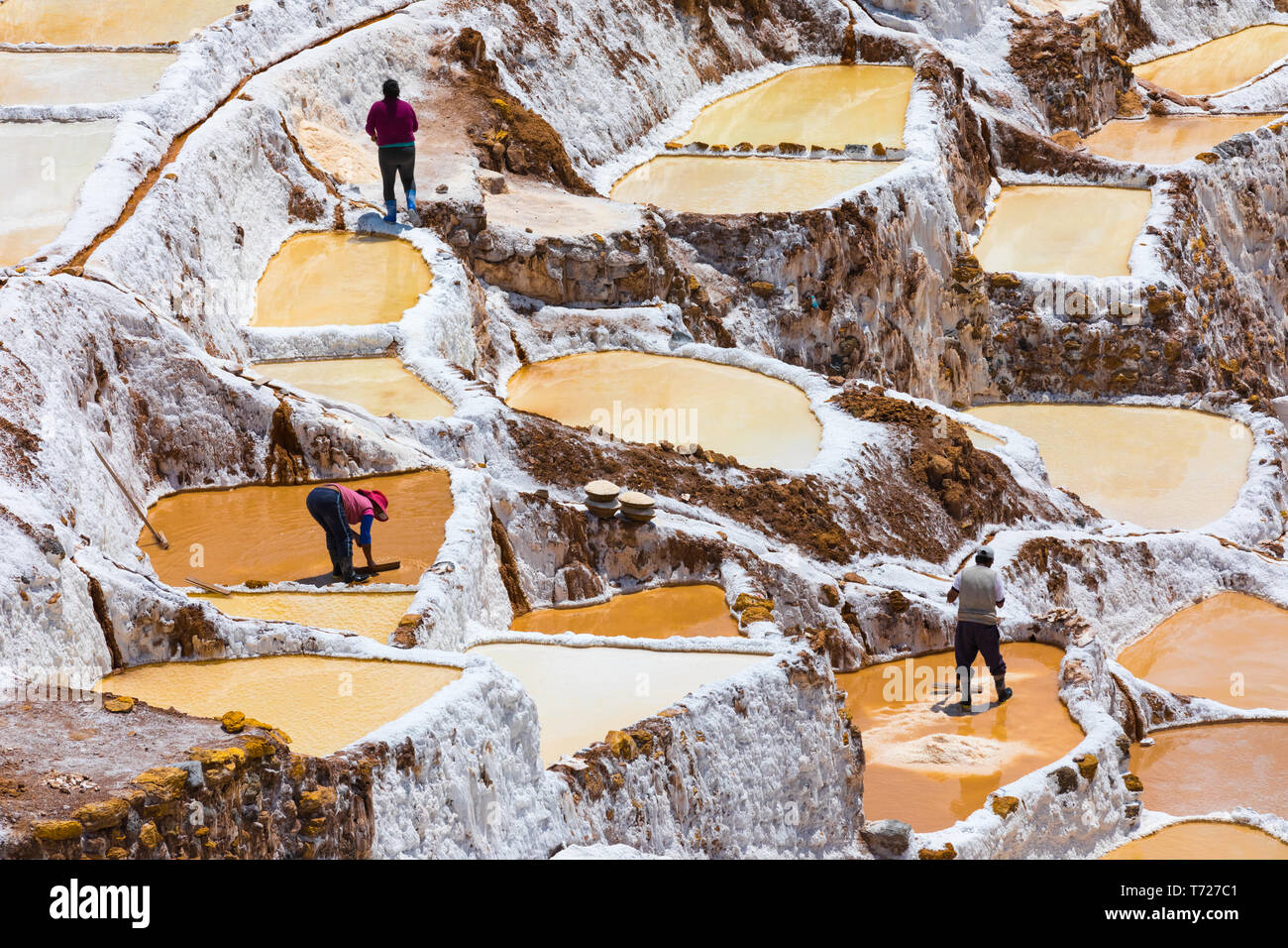 people at work in the saltpans of Moray Peru Stock Photo