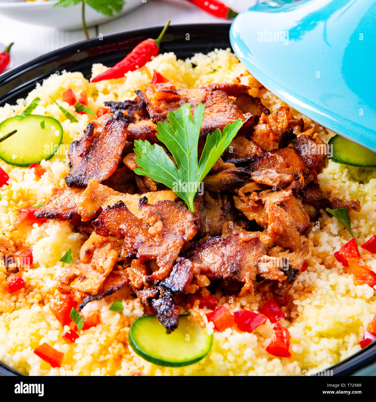 Tajin with couscous, vegetables and meat on white background Stock