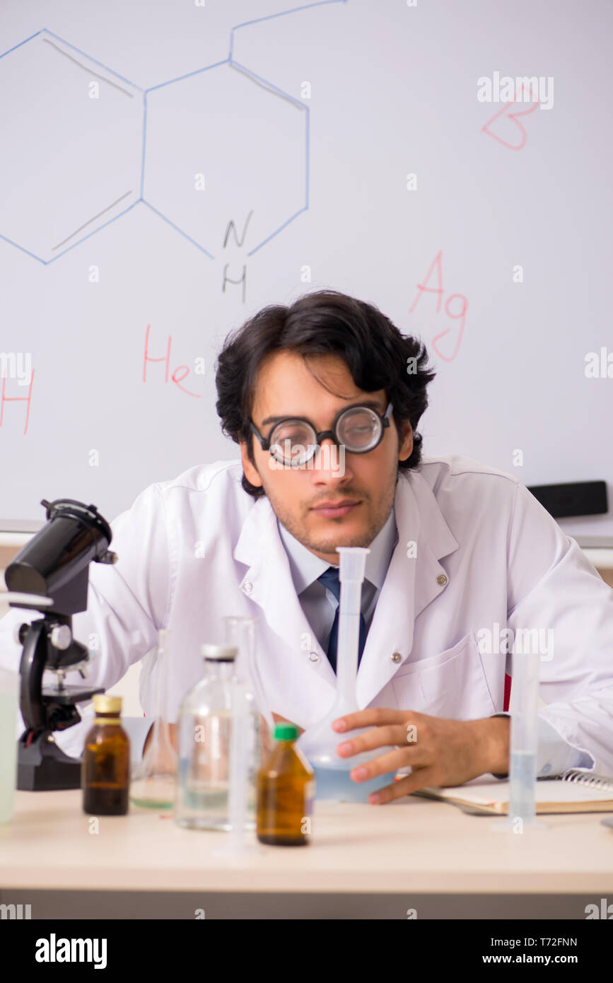 Young funny chemist in front of white board Stock Photo