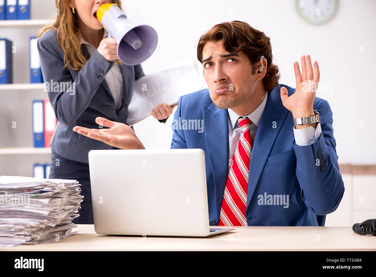 Deaf employee using hearing aid talking to boss Stock Photo