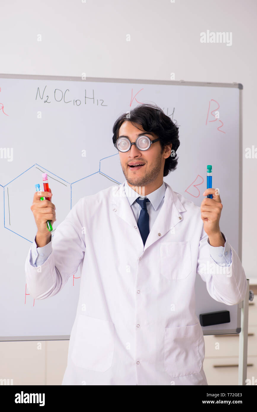 Young funny chemist in front of white board Stock Photo