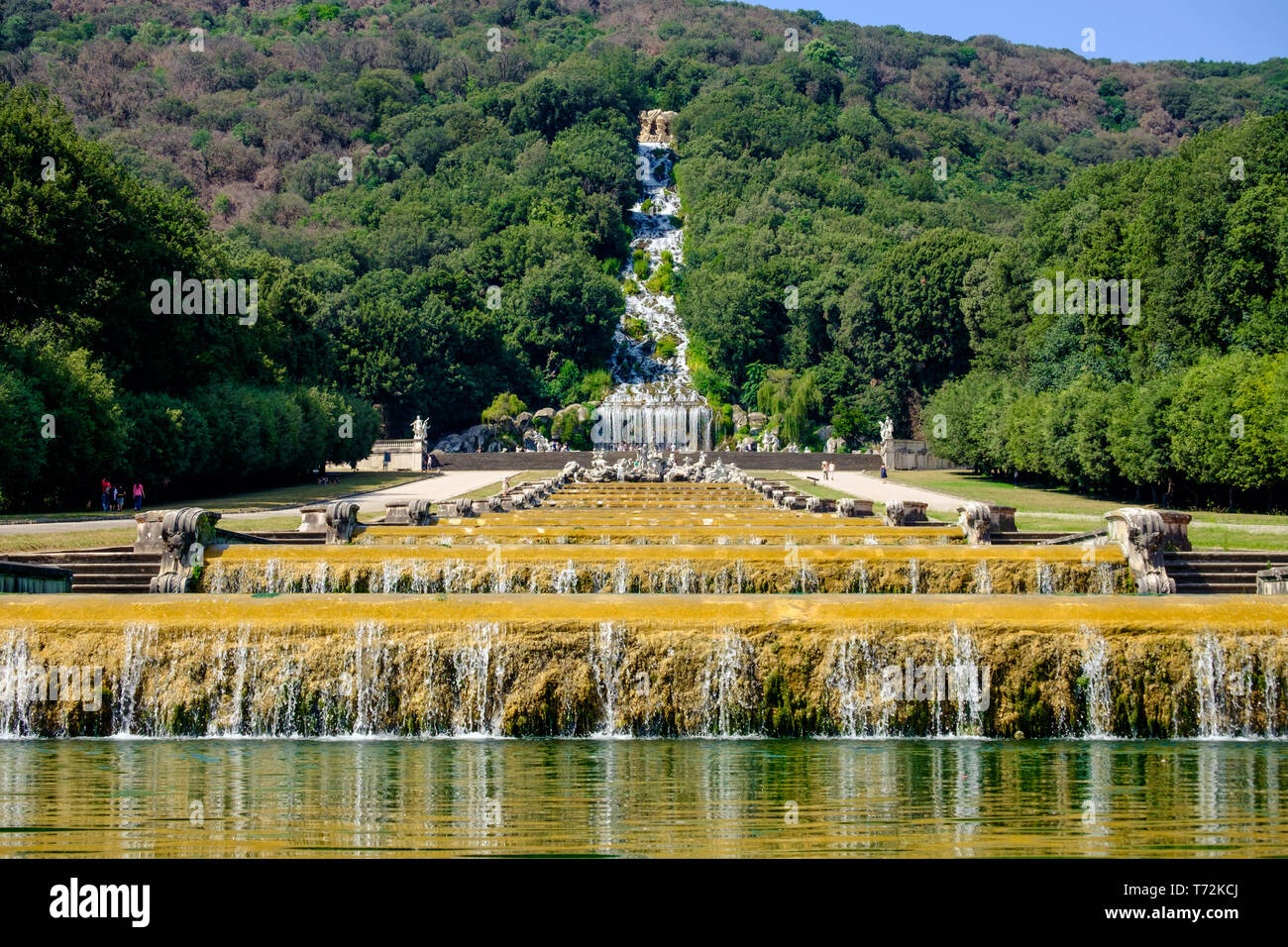Large water basins are the center of the gardens of the 'Reggia di Caserta'. In the distance, you see a high artificial waterfall. Stock Photo