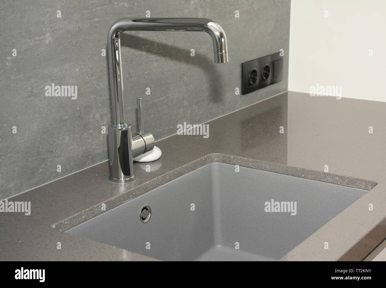 Ceramic kitchen sink. Modern kitchen metal faucet and  ceramic kitchen sink. Stock Photo