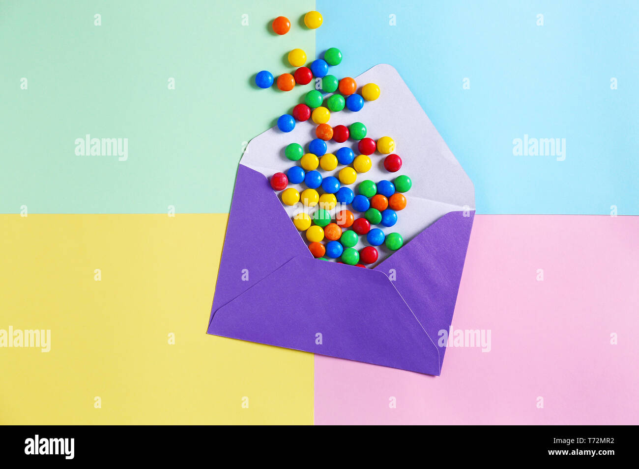 Mail envelope with candies on color background Stock Photo Alamy
