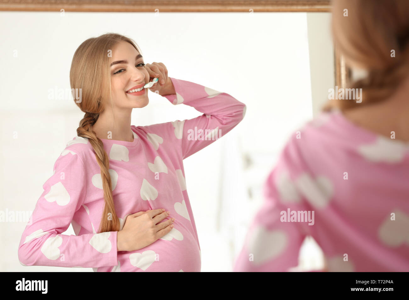 Young pregnant woman cleaning teeth in bathroom Stock Photo - Alamy