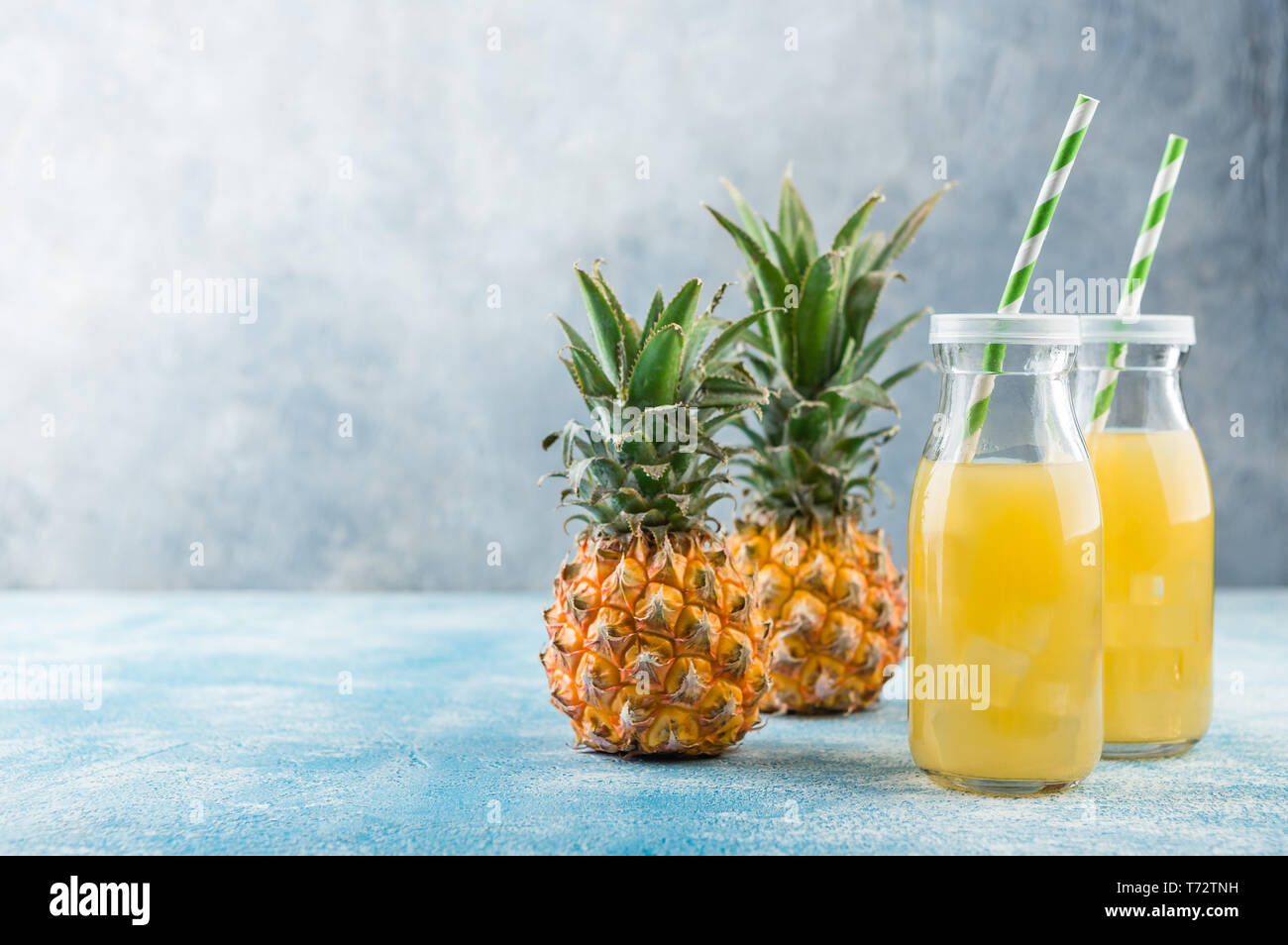 Fresh pineapple juice and ripe pineapple on grey background Stock Photo ...