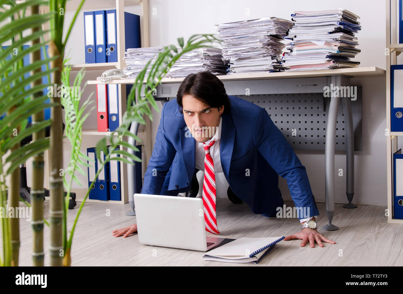 Young businessman employee unhappy with excessive work Stock Photo