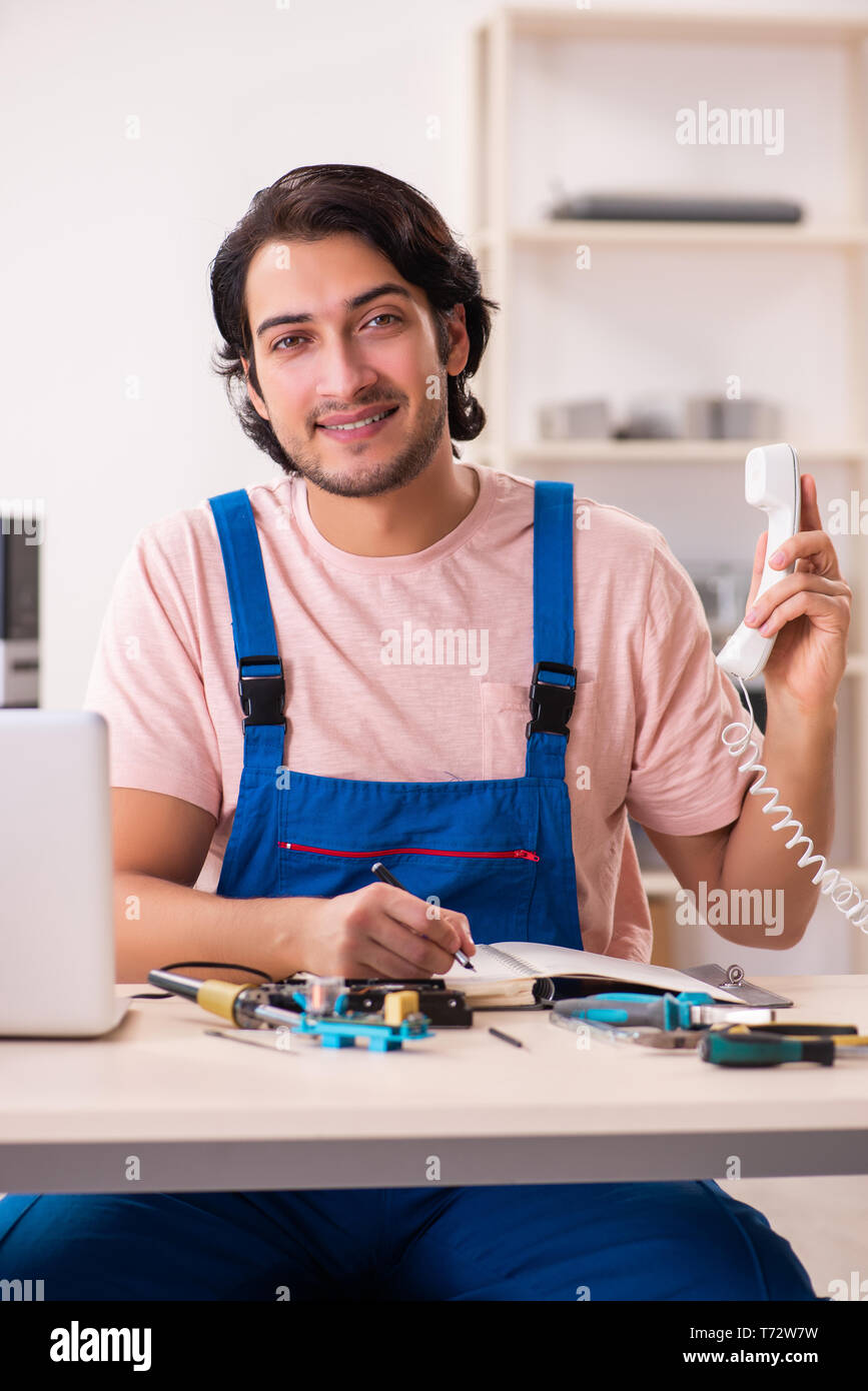 Young male contractor repairing computer Stock Photo