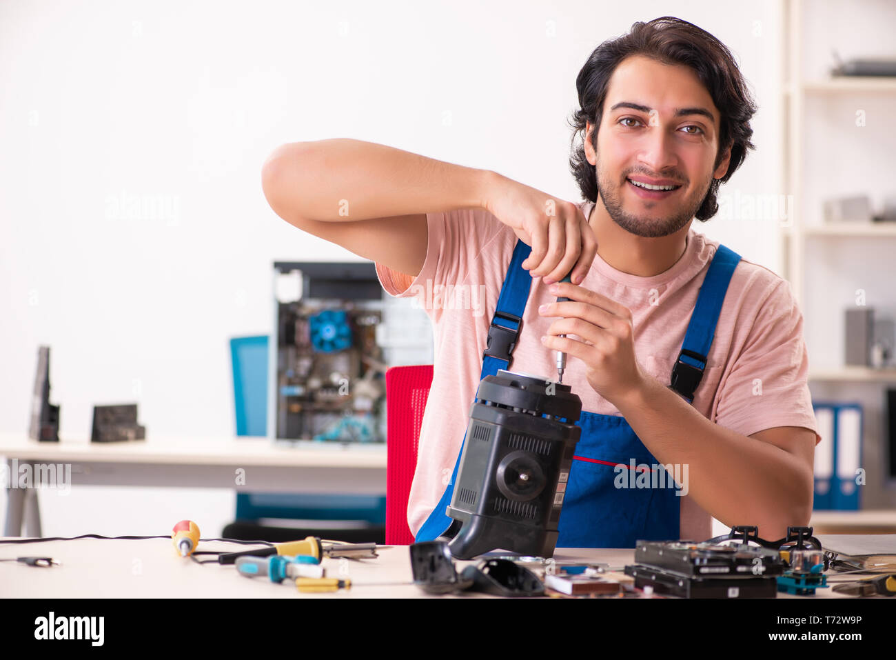 Young male contractor repairing computer Stock Photo