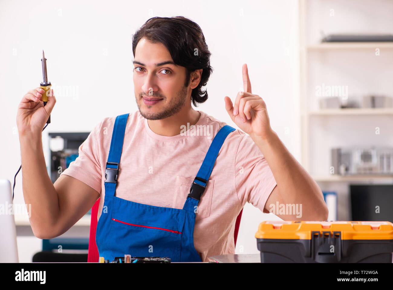 Young male contractor repairing computer Stock Photo