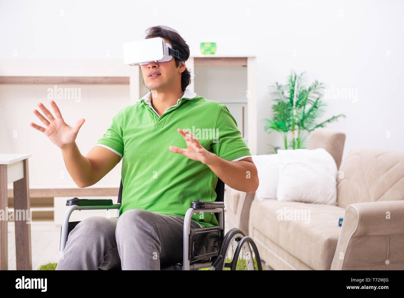 Young handsome man in wheelchair at home Stock Photo