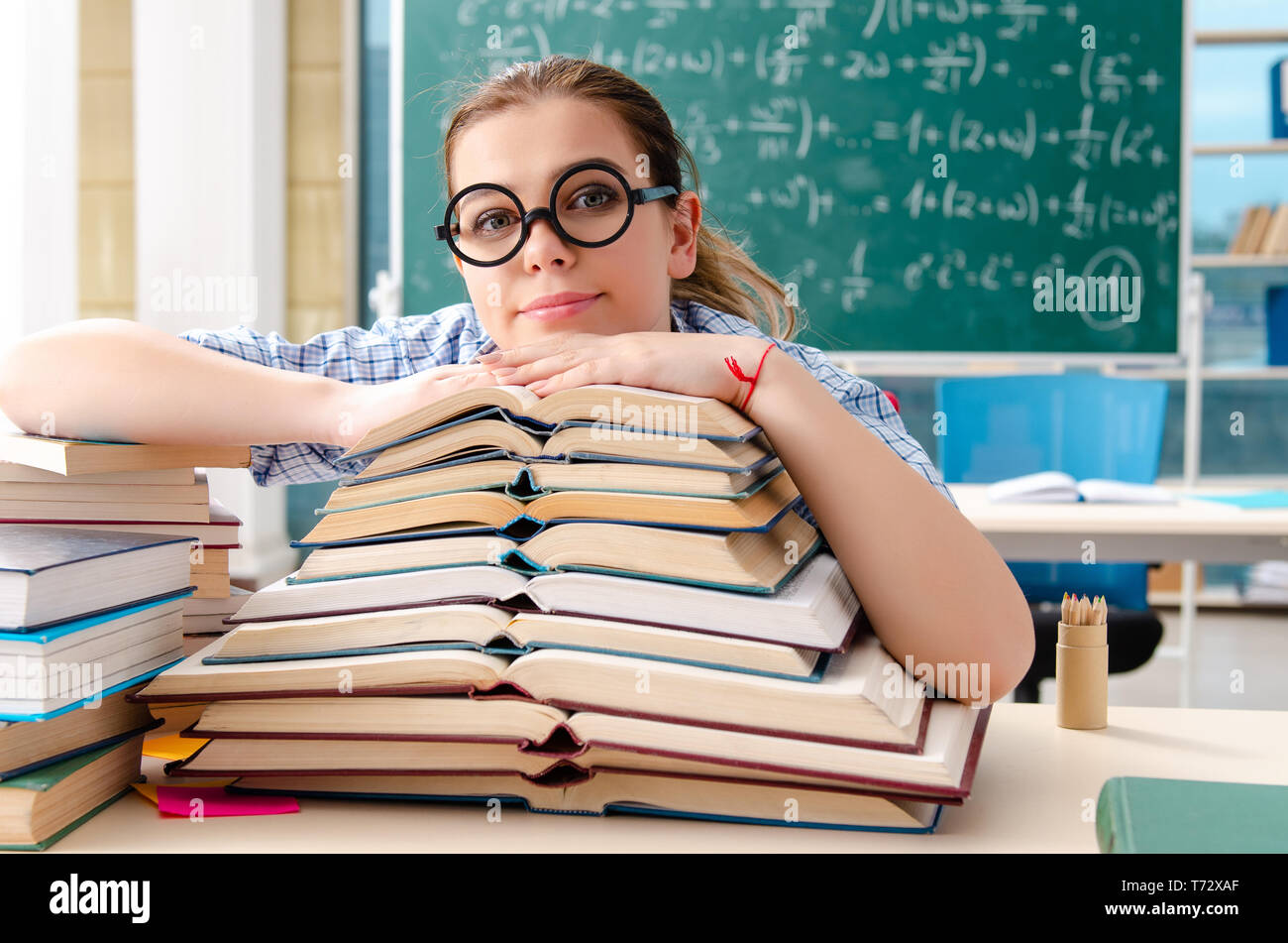 Female student with many books sitting in the classroom Stock Photo - Alamy