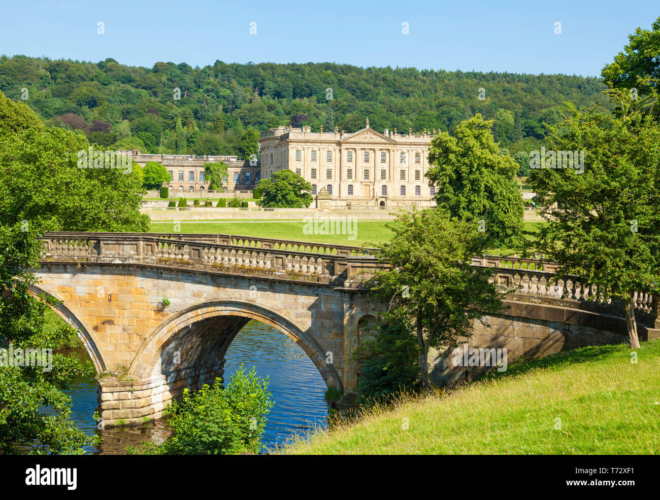 Chatsworth House park with an entrance bridge over the river Derwent parkland and woods Derbyshire England UK GB,  Europe Stock Photo