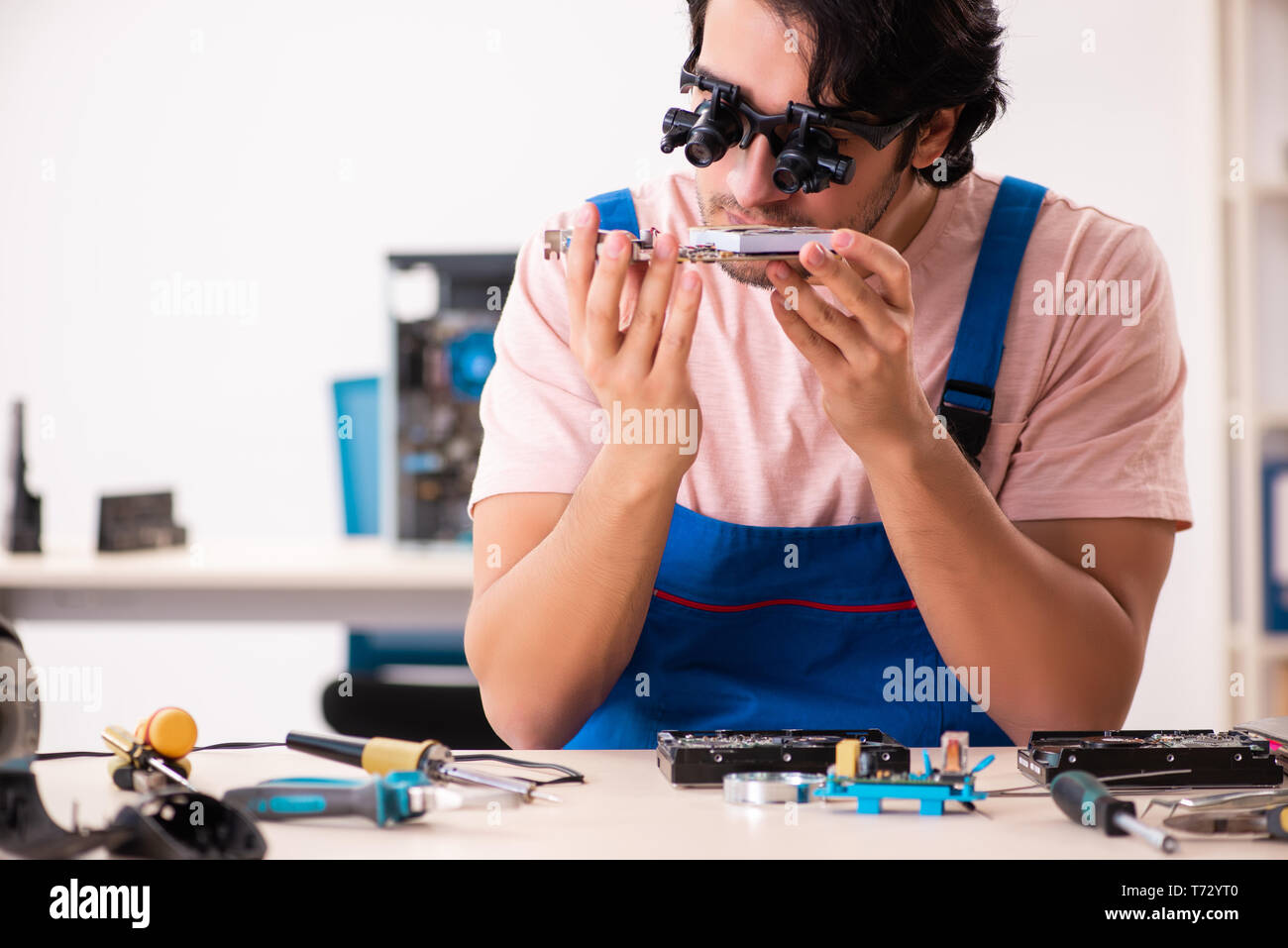 Young male contractor repairing computer Stock Photo