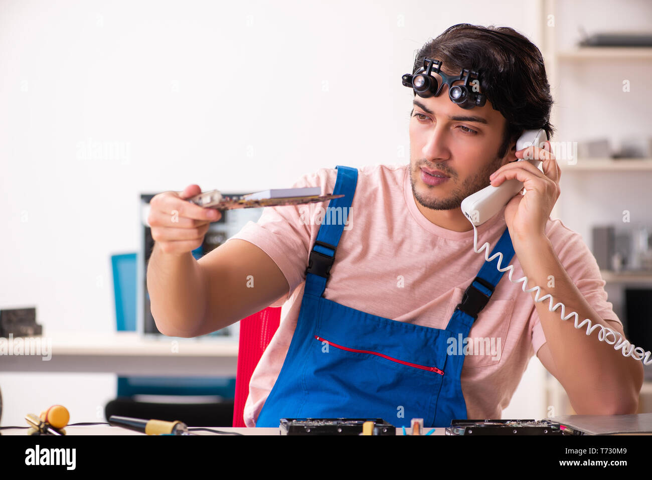 Young male contractor repairing computer Stock Photo