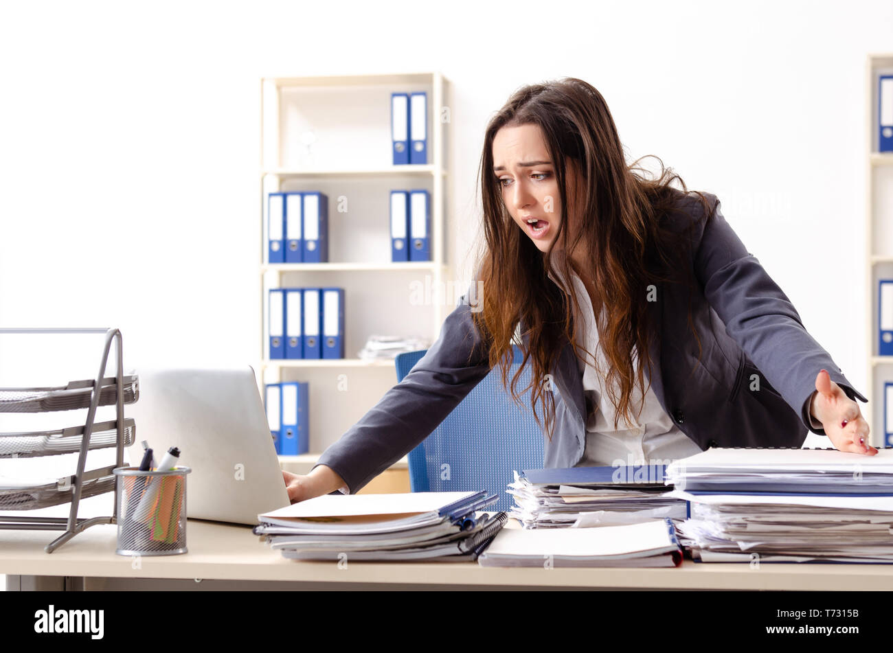 Young female employee unhappy with excessive work Stock Photo