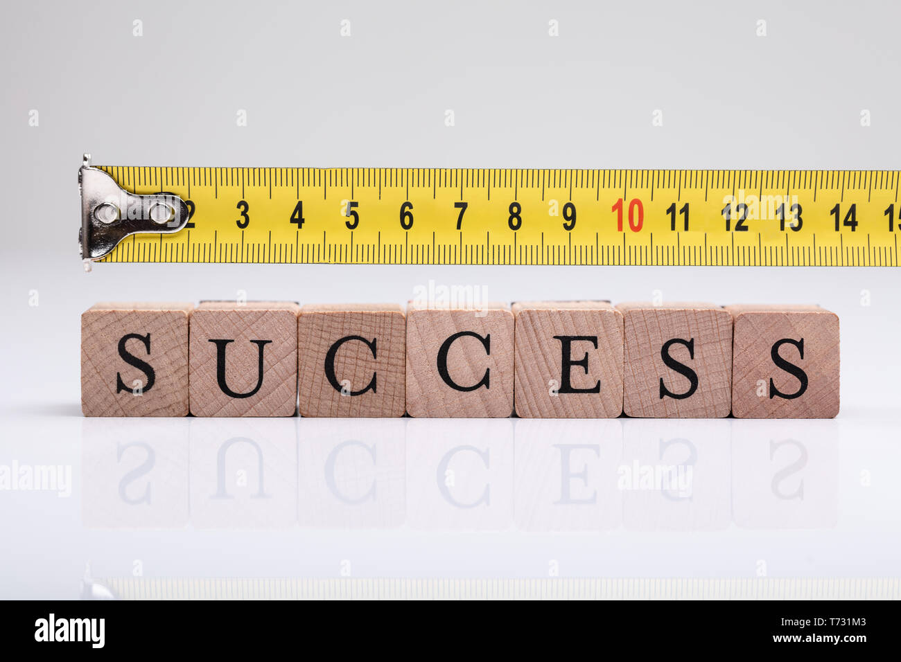 Measurement Of Success Word On Wooden Blocks Using Measuring Tape Stock Photo