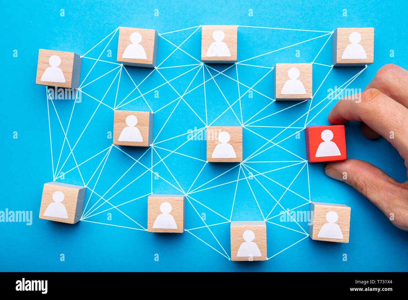 Person's Hand Holding Connecting Icon People Wooden Cube Block For Social Media Networking Stock Photo