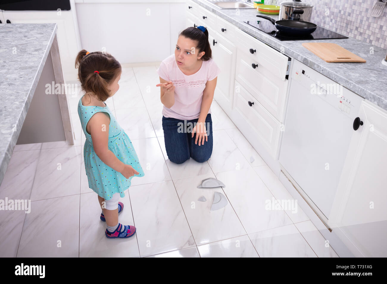 Mother Shouting To Her Daughter While Broken The Plate Stock Photo