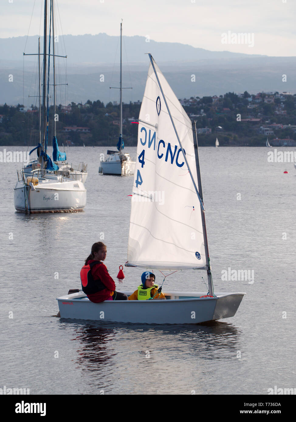 Villa Carlos Paz, Cordoba, Argentina - 2019: Children ride a sailboat at San Roque Lake, one of the main attractions of this touristic city. Stock Photo