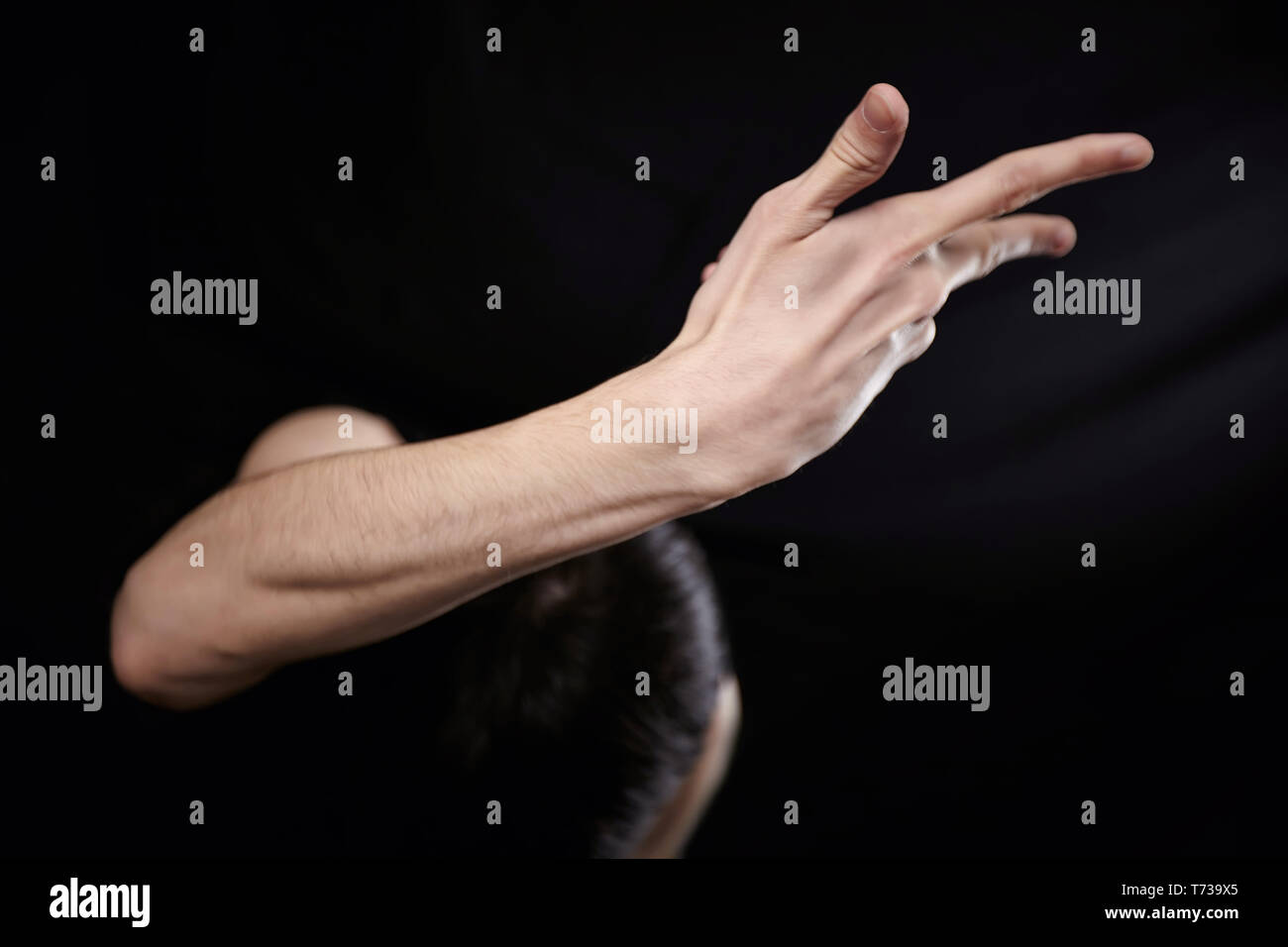 Empty man pointing finger on black background Stock Photo